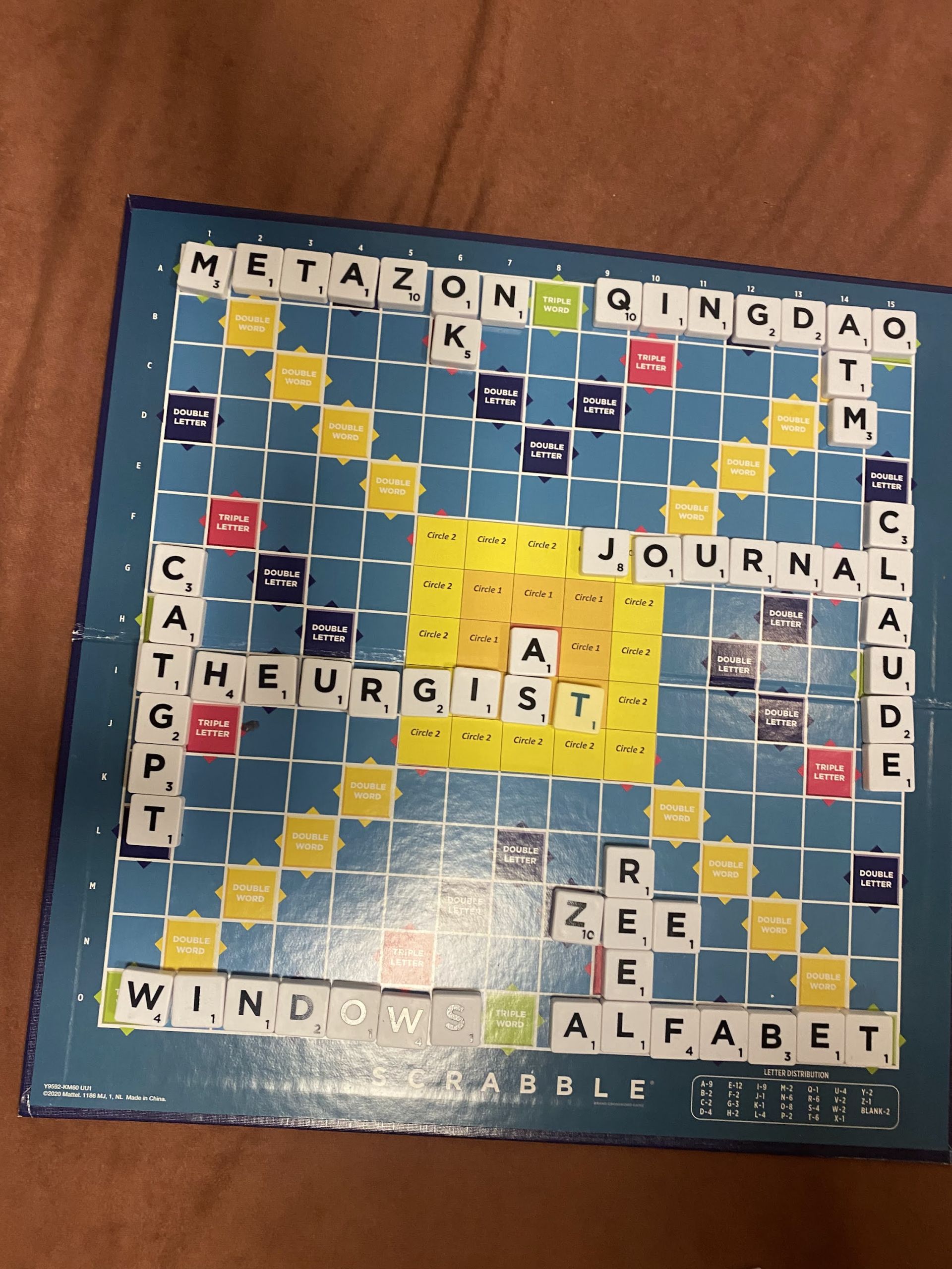 Scrabble board filled with playful words like METAZON, QINGDAO, CATGPT, THEURGIST, CLAUDE and JOURNAL.
